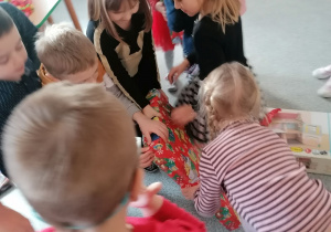 Dzieci odpakowują prezenty od Mikołaja.